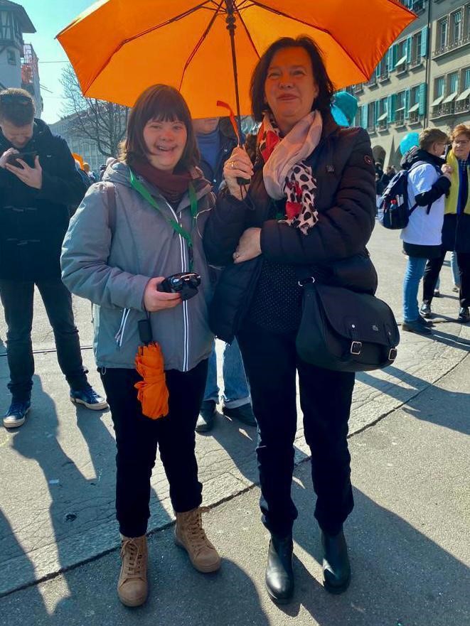 Mutter mit Tochter unter orangem Schirm